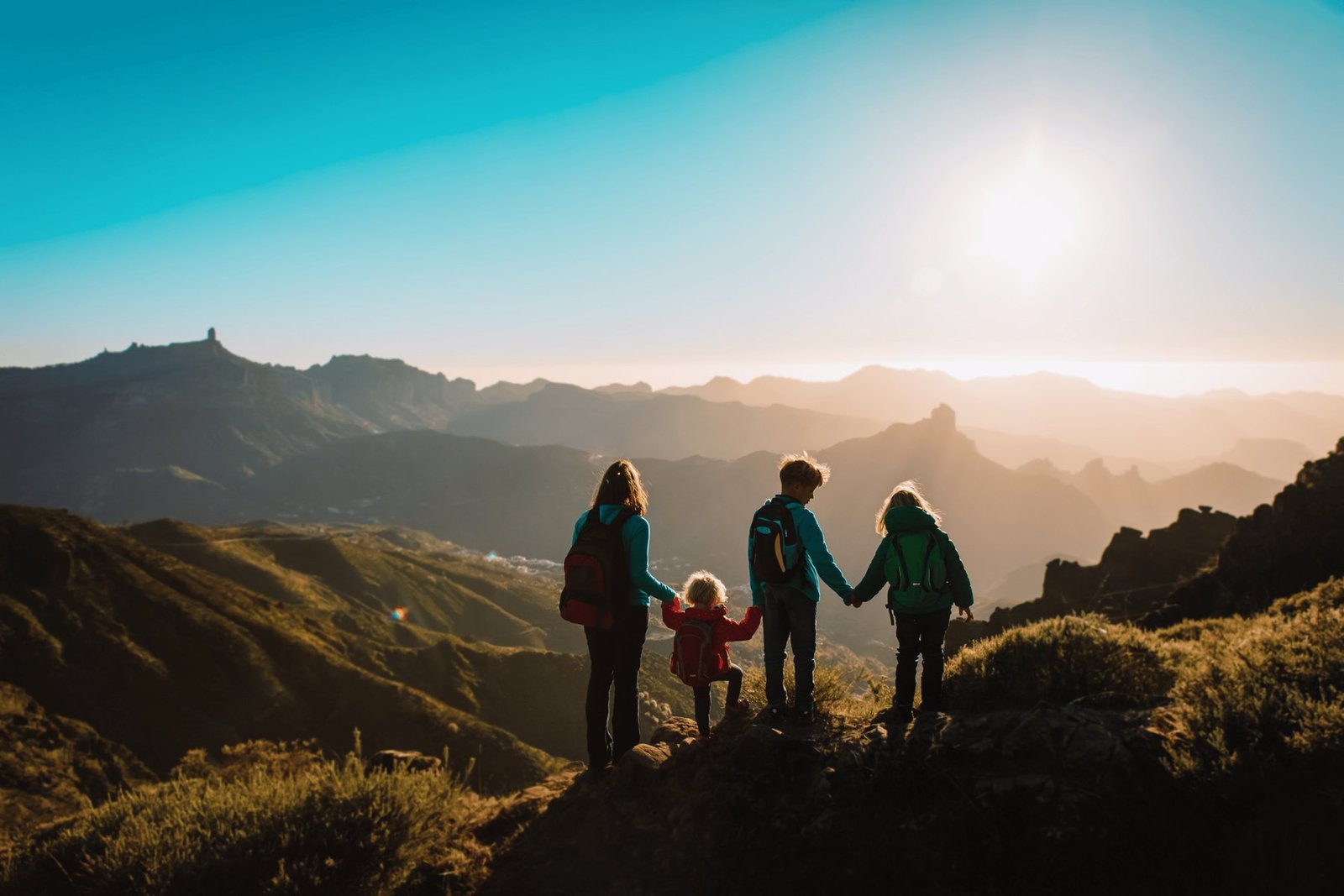 A family hiking together through a mountain landscape at sunset